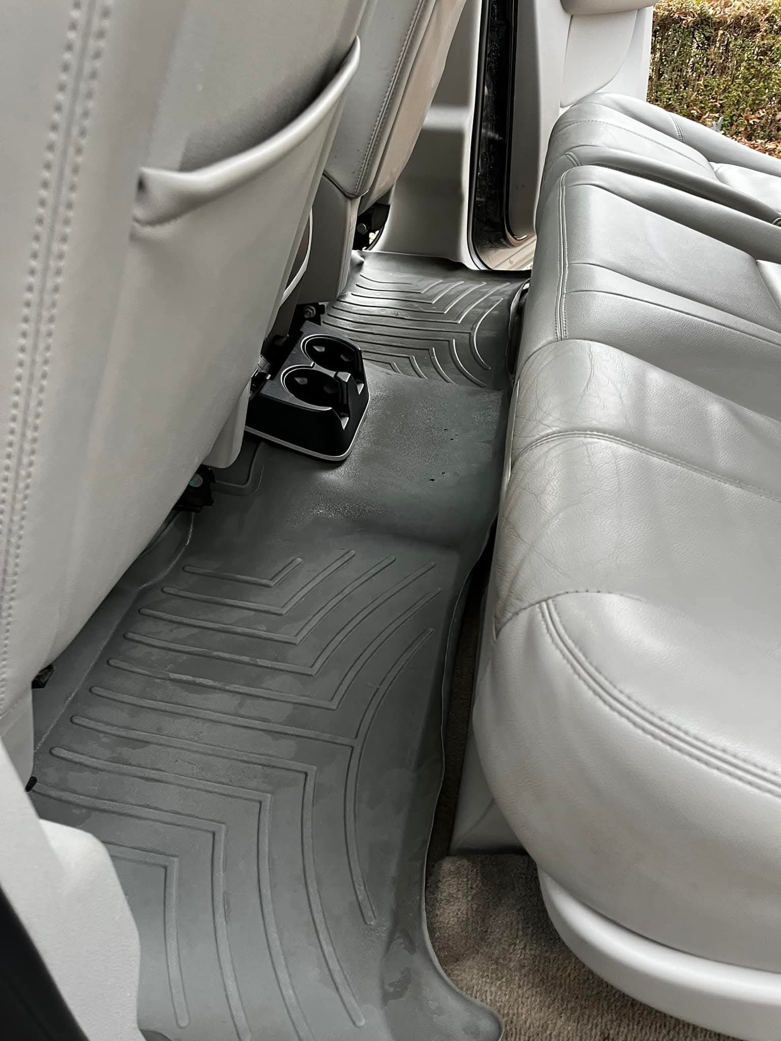 Clean floor mat after interior detail — leather seats visible
